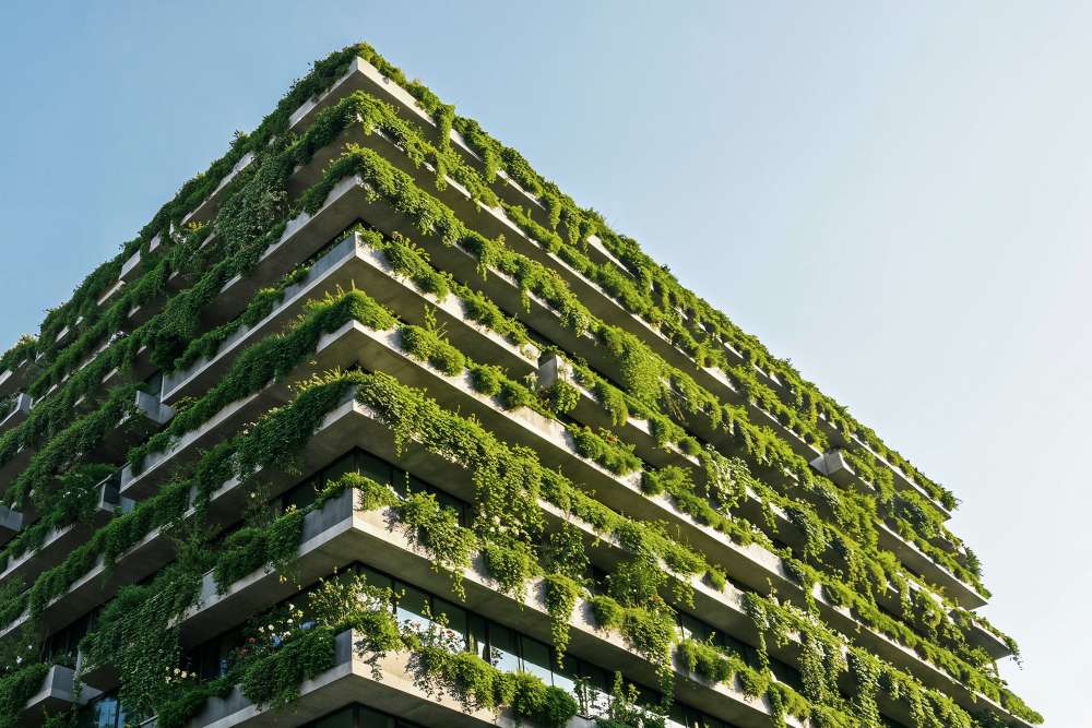 Immeuble moderne avec façades végétalisées et terrasses recouvertes de plantes vertes