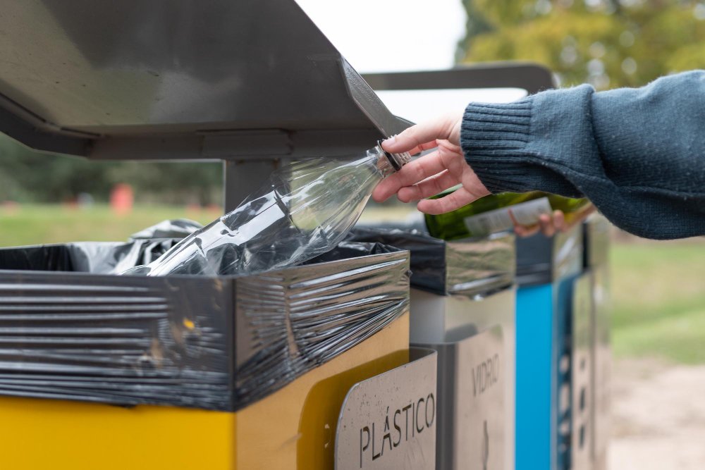 homme jetant une bouteille à la poubelle